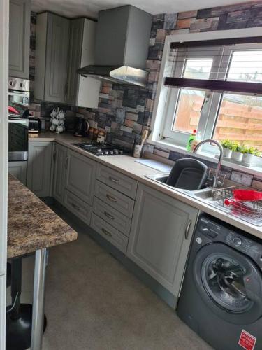 a kitchen with a washing machine and a sink at North Coast Property - Number 15 in Thurso