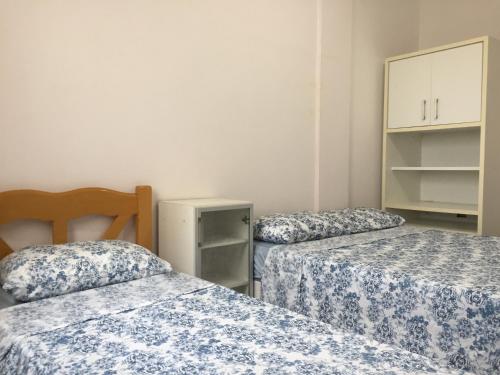Cette chambre comprend 2 lits avec des draps bleus et blancs. dans l'établissement APARTAMENTO 3 DORM., O QUINTAL É A PRAIA E MOLHES, à Laguna