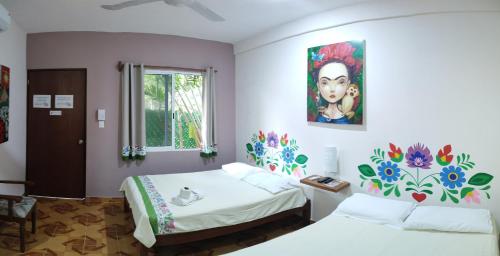 a bedroom with two beds and a painting on the wall at Casona del Negro Aguilar in Valladolid