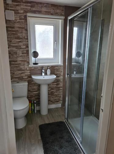 y baño con aseo, lavabo y ducha. en North Coast Property - Number 15, en Thurso