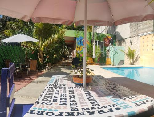 a table with an umbrella next to a swimming pool at Casona del Negro Aguilar in Valladolid