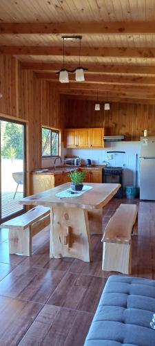 a large kitchen with a large table and benches at Paraíso Liumalla Lodge in Villarrica