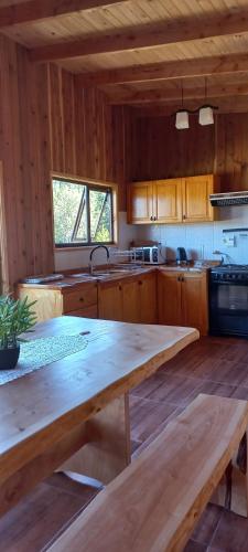 a large kitchen with a large wooden table in it at Paraíso Liumalla Lodge in Villarrica