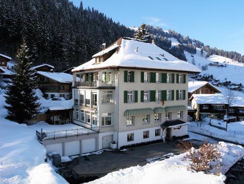 a large white building with snow on top of it at Sonnegg Hotel in Zweisimmen