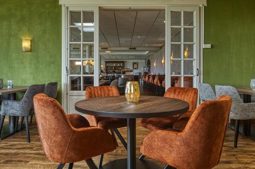 une salle à manger avec une table et des chaises dans l'établissement Landgoed Hotel Tatenhove Texel, à De Koog