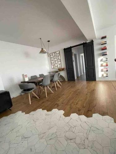a living room with a table and chairs in it at Modern 2-bedroom apartment in new residence in Craiova