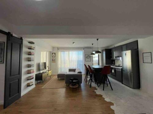 a kitchen and living room with a table and chairs at Modern 2-bedroom apartment in new residence in Craiova