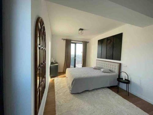 a bedroom with a bed and a large window at Modern 2-bedroom apartment in new residence in Craiova