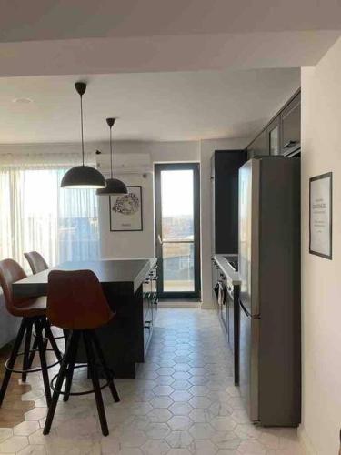 a kitchen with a refrigerator and a table and chairs at Modern 2-bedroom apartment in new residence in Craiova