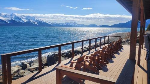 une terrasse avec des chaises sur la rive d'une masse d'eau dans l'établissement Resurrection Lodge on the Bay, à Seward