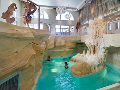 a pool in a water park with two people in it at Superbe Appartement 6 personnes Ski-in Ski-out Arc 1950 in Bourg-Saint-Maurice