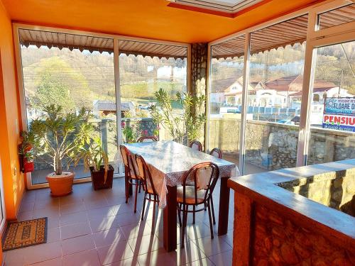 a dining room with a table and chairs on a balcony at Floare de Colt Petrosani in Petroşani