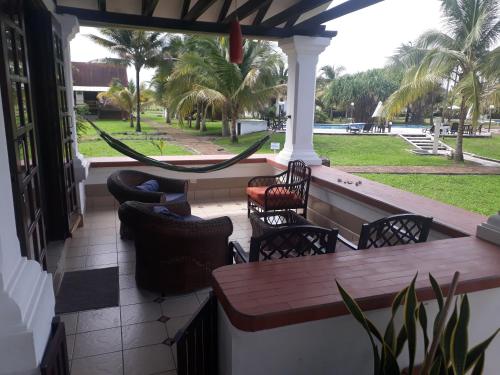 a porch with a table and chairs and a hammock at Conjunto vacacional Cocomar-Casa 6-5h in Carrizal