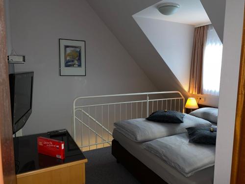 ジンデルフィンゲンにあるT24 - Ihr Appartement mit Charakterのベッド2台とテレビが備わるホテルルームです。