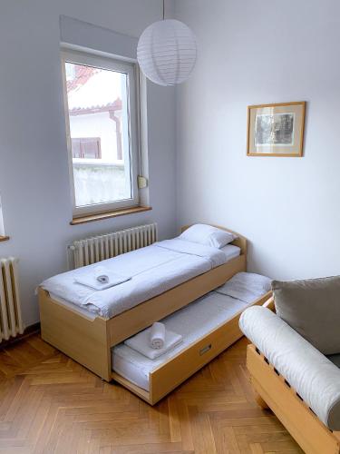 two beds in a room with a window at Bueno Apartment in Belgrade