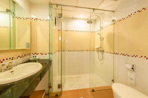 y baño con ducha acristalada y lavamanos. en Caesar Palace Hotel, en Pattaya central