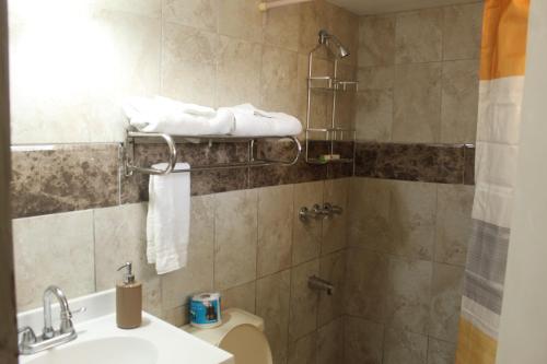 a bathroom with a toilet and a sink and a shower at Comfy, Central & Elegant Studio New Kingston in Kingston