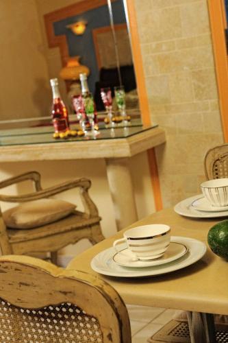 a table with a mirror and a table with plates and cups at Parthenis Hotel & Suites in Malia