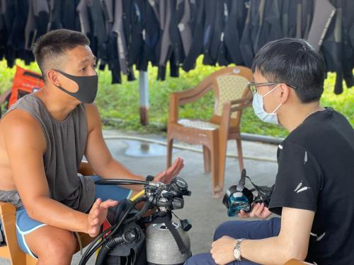 two people sitting on a motorcycle with a mask on at Stay Liuqiu Diving Hostel in Xiaoliuqiu