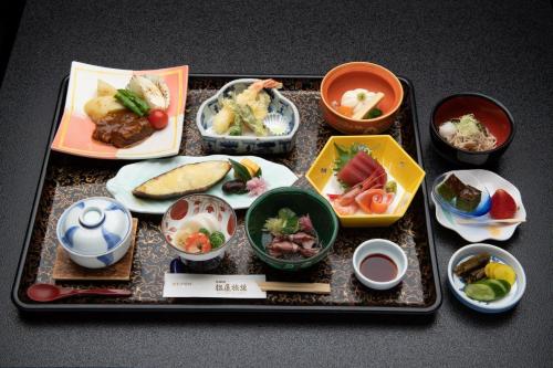 a tray filled with dishes of food on a table at Jizokan Matsuya Ryokan in Nagano