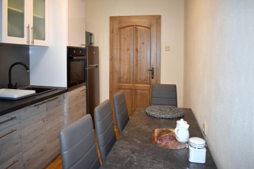 a kitchen with a table and some chairs and a table and a kitchen at Chalupa pod Tatrami in Liptovská Teplička