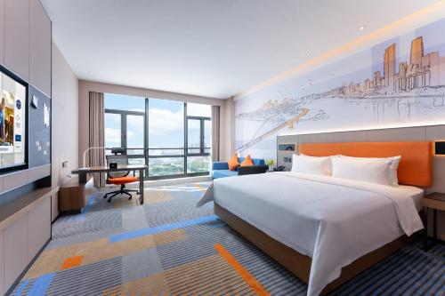 広州市にあるHampton by Hilton Guangzhou Jinshazhouのベッドとデスクが備わるホテルルームです。