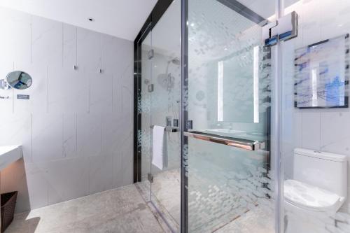 uma casa de banho com uma cabina de duche em vidro e um WC. em Hampton by Hilton Guangzhou Jinshazhou em Guangzhou