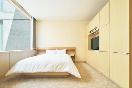 a bedroom with a bed and a tv at Shonai Hotel Suiden Terrasse in Tsuruoka