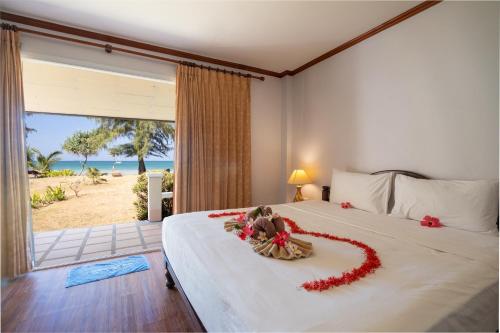 a bedroom with a bed with a heart made out of flowers at Gooddays Lanta Beach Resort SHA in Ko Lanta