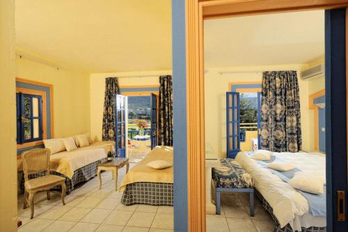a bedroom with two beds and a living room at Parthenis Hotel & Suites in Malia