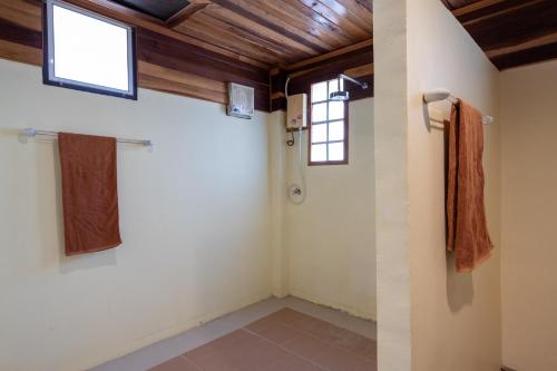 Habitación con 2 ventanas y ducha. en Gooddays Lanta Beach Resort SHA, en Ko Lanta