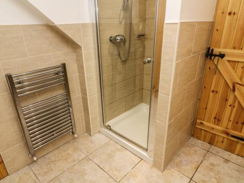 a shower with a glass door in a bathroom at Anvil Barn in Bainbridge