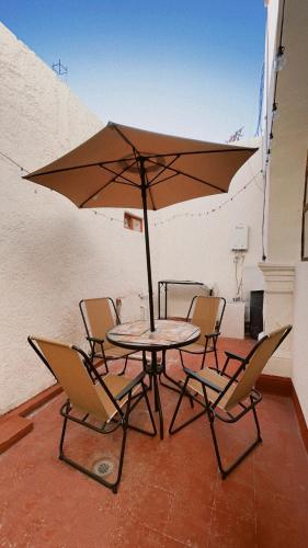 a table with chairs and an umbrella on a balcony at Hostal La española Parras in Parras de la Fuente