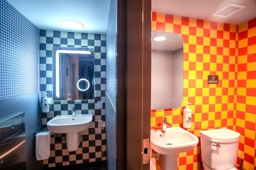 a bathroom with a sink and a toilet at Pangea Pod Hotel in Whistler