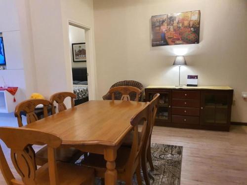 a dining room with a wooden table and chairs at Gerard's Place Nature Haven Apartment in Tanah Rata