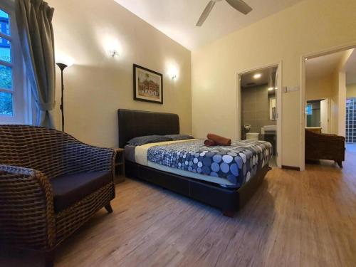 a bedroom with a bed and a chair in it at Gerard's Place Nature Haven Apartment in Tanah Rata