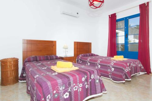 プラヤ・ブランカにあるAcomariの赤と紫の部屋のベッド2台