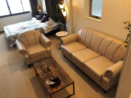 sala de estar con sofá, sillas y mesa en Cool-inn Otaru, en Otaru