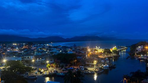 uma cidade à noite com barcos na água em Hostel Vista da Barra em Florianópolis