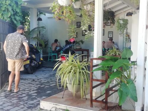 a person standing outside of a house with plants at The Classic-hostel-apt-deluxe in Weligama