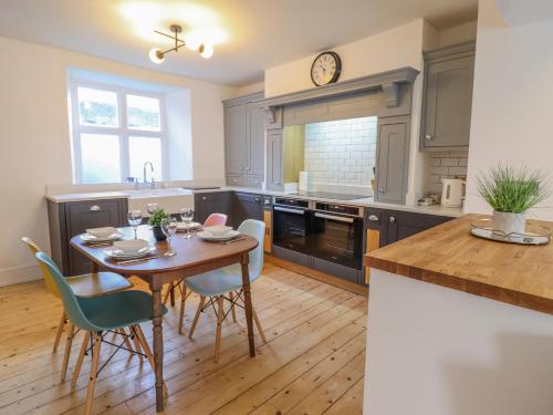 a kitchen with a table and chairs in a kitchen at Harbourside in Porthmadog