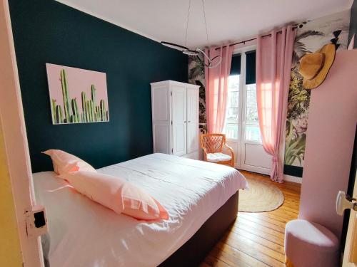 a bedroom with a bed and a green wall at Les Terrasses de Puys in Puys