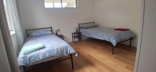 1 dormitorio con 2 camas y ventana en Rising Sun, en Russell Island