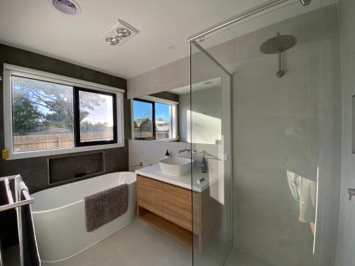 uma casa de banho com uma banheira, um lavatório e um chuveiro em Beautiful New Holiday Place 5 Mins To Beach With Kitchen And Office Nook em Safety Beach