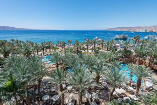 an aerial view of a resort with palm trees and the ocean at Royal Beach Eilat by Isrotel Exclusive in Eilat