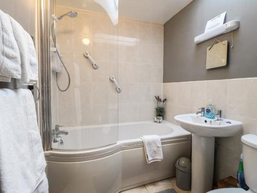 a bathroom with a shower and a tub and a sink at Number 5 in Buxton