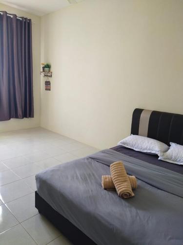 a bedroom with a bed with two pillows on it at Afiyah Guesthouse in Padang Besar