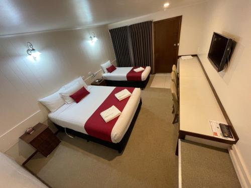 a hotel room with two beds and a television at Jerilderie Motor Inn in Jerilderie
