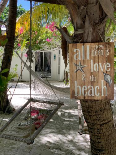 a hammock tied to a tree with a sign on it at Kahanbu Ocean View in Thulusdhoo