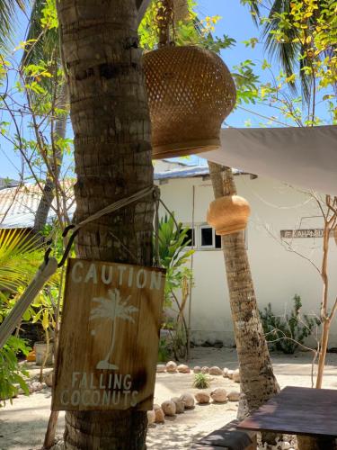 a sign on the side of a palm tree at Kahanbu Ocean View in Thulusdhoo